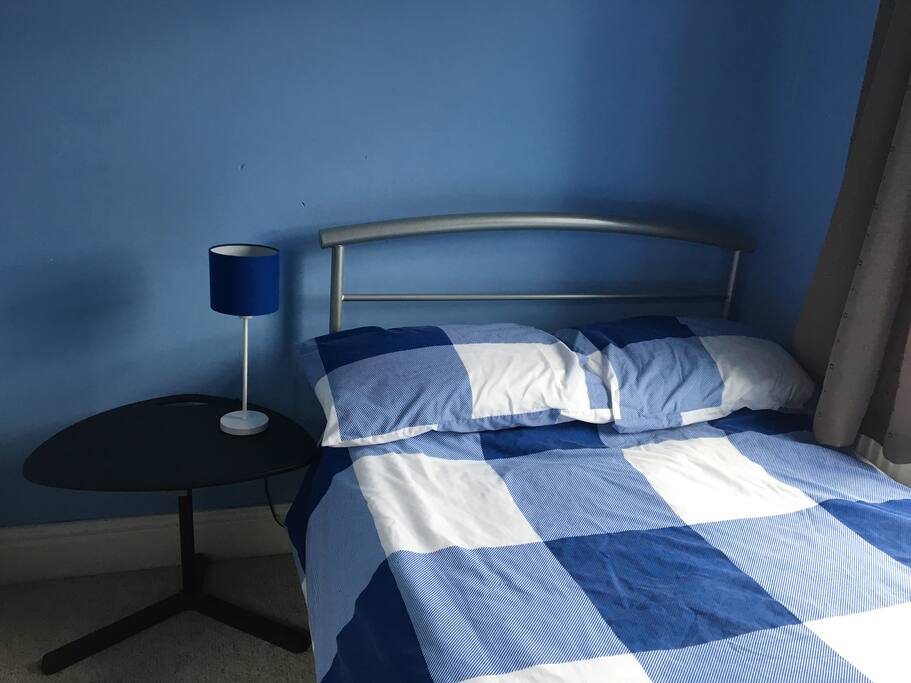 The bedside table is also a small laptop desk, and there is a chair in the room