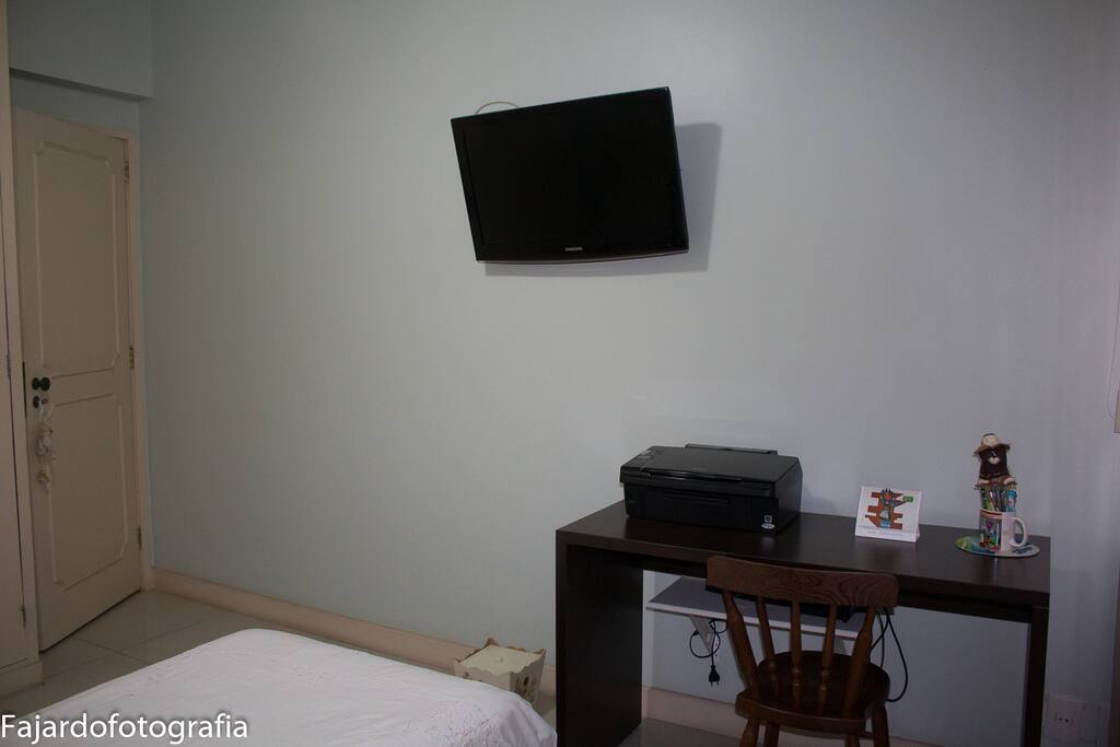 Quarto com uma cama de solteiro.