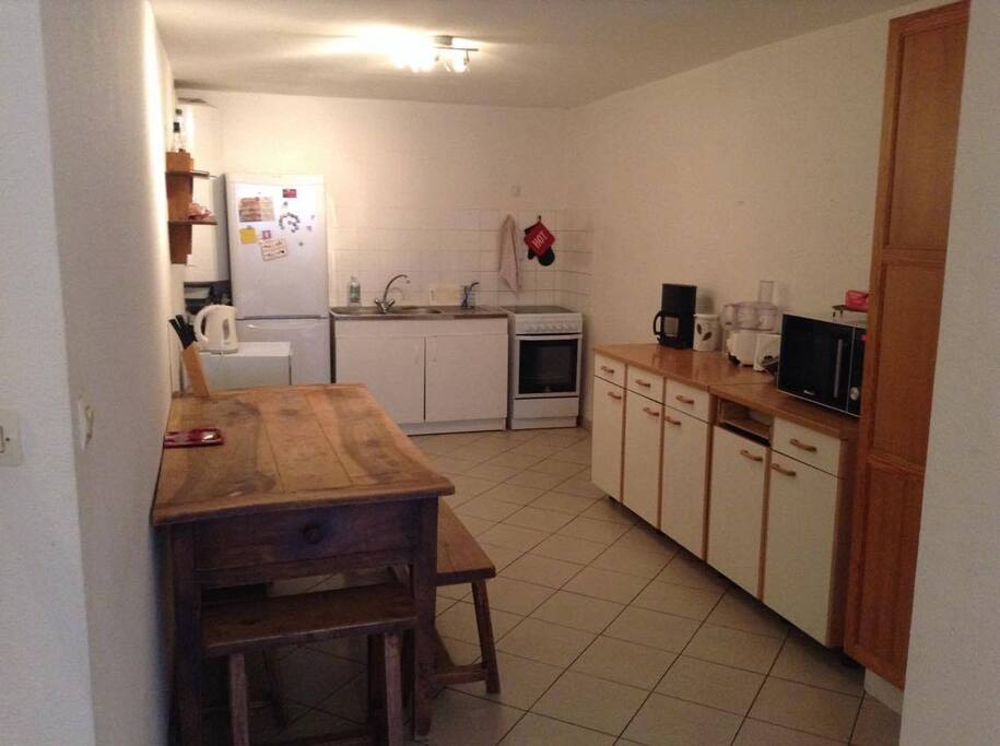 Grande cuisine équipée ouverte sur salon. Un autre banc est sous la table si vous voulez vous faire de grand repas jusqu'à 8 personnes.