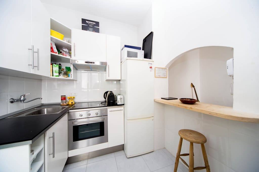 Cocina completa y con mucha luz . Barra y mesa para desayunar.
