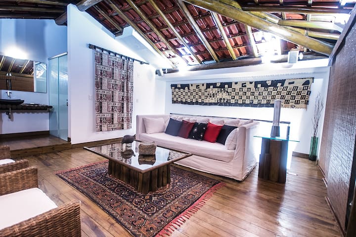 Telhado: living room on 12th floor with exposed beams and red tile roof, African textiles: my favorite room to relax
