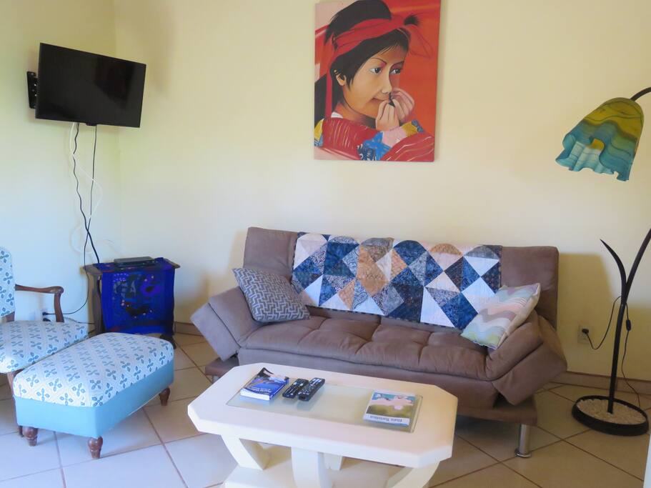 Comfortable living area with wall mounted television. Couch converts to a sofa bed for extra sleeping.