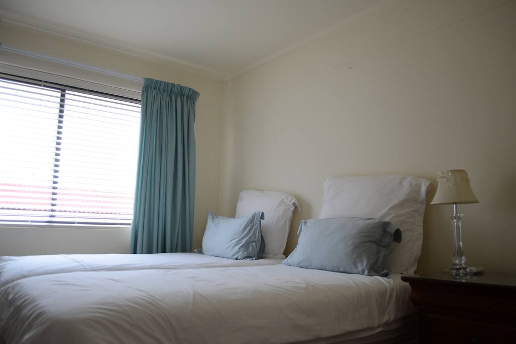 Bedroom with two single beds and air conditioning.
