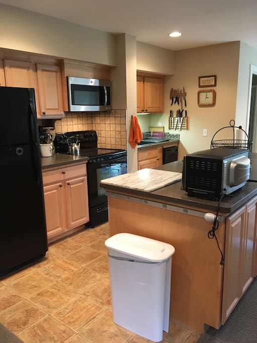 Full kitchen includes electric range, microwave, refrigerator, dishwasher, and sink with garbage disposal.