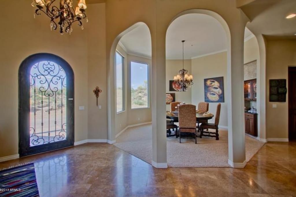 Great entry door, high ceiling and travertine stone flooring