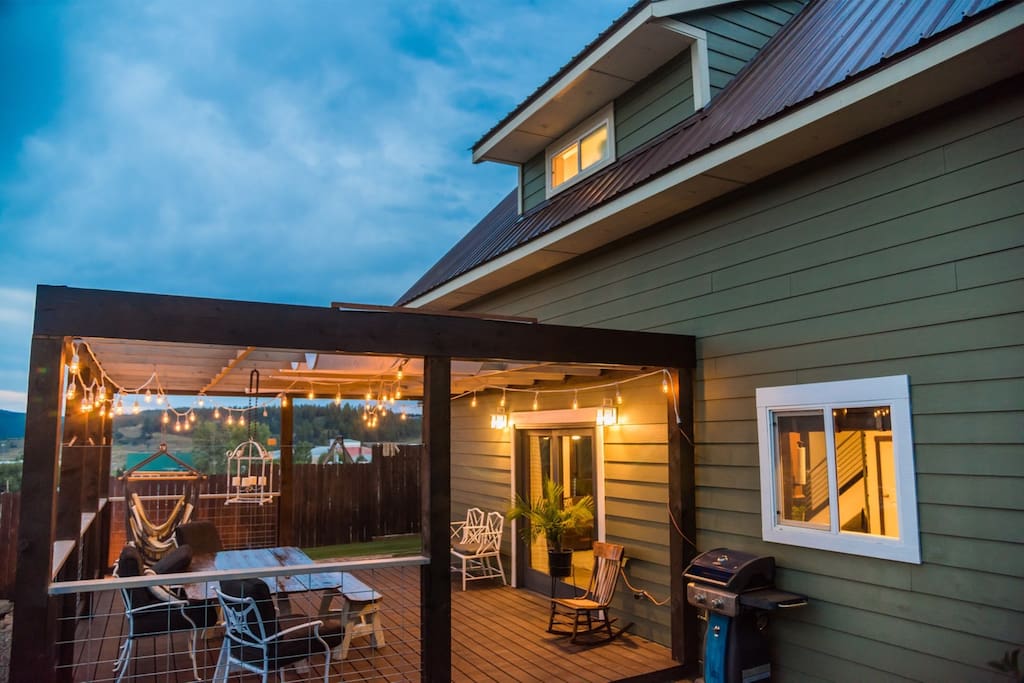 Private, fenced backyard with table, chairs, hammocks, and a fire pit