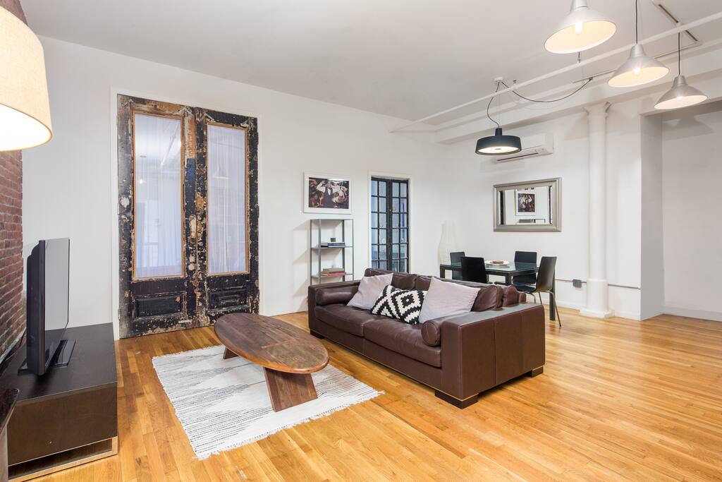 Comfortable living room with wooden floor and adjacent kitchen table.