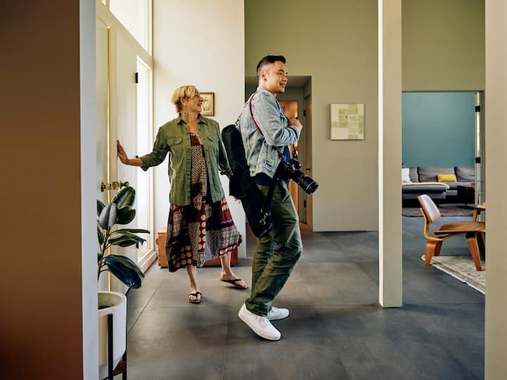 Host greets photographer in their home