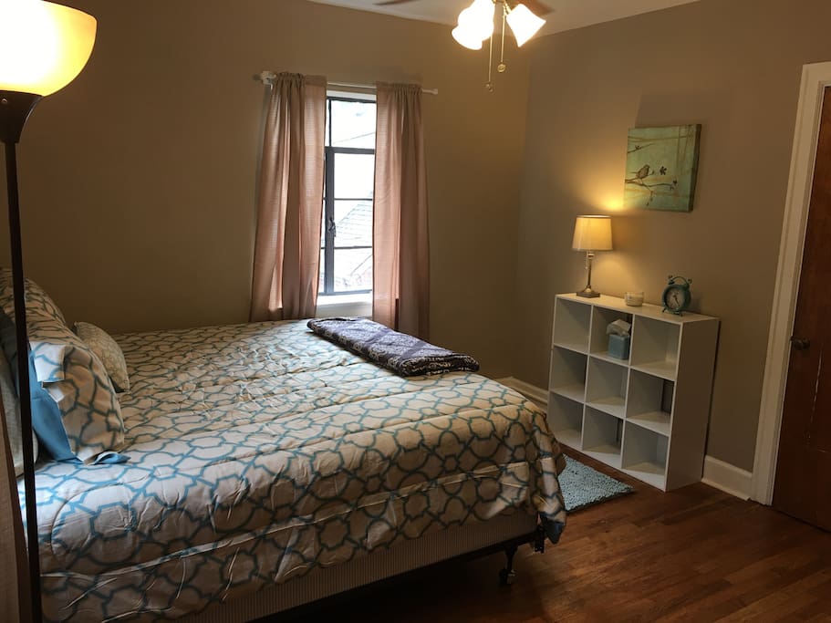 Cozy master bedroom has a king bed