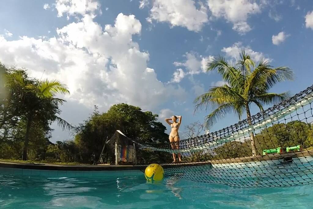 Piscina rodeada de verde grama e vegetação natural