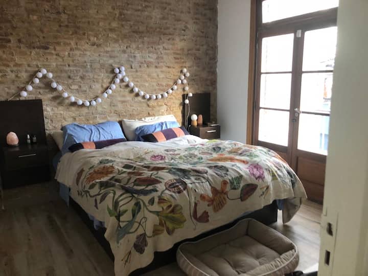 La chambre principale dispose d'une fenêtre qui donne sur un balcon donnant sur la rue