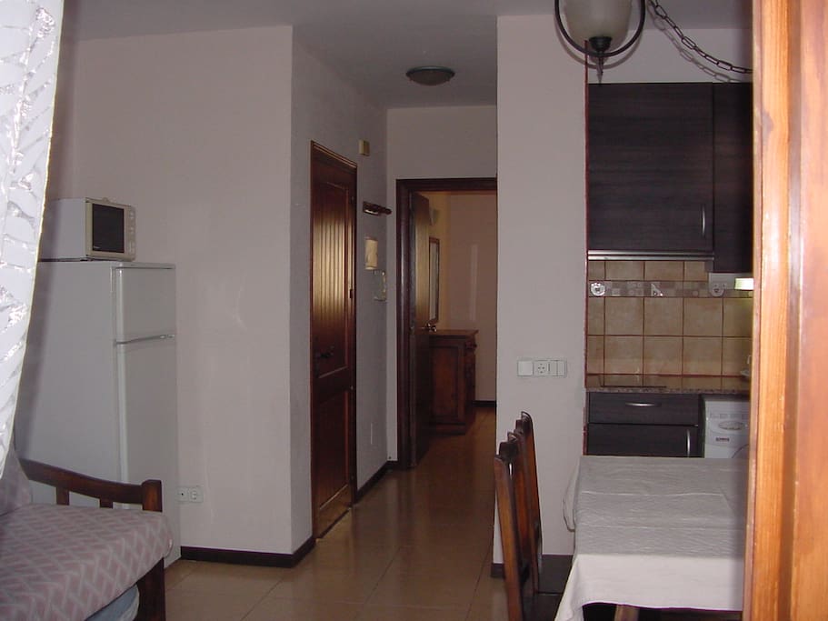 Preliminary picture of the apartment on the ground floor of a two story row house complex. The terrace and sea view is opposite this picture and here you see parts of the kitchen living room with beds and the bathroom and private bedroom further inside.