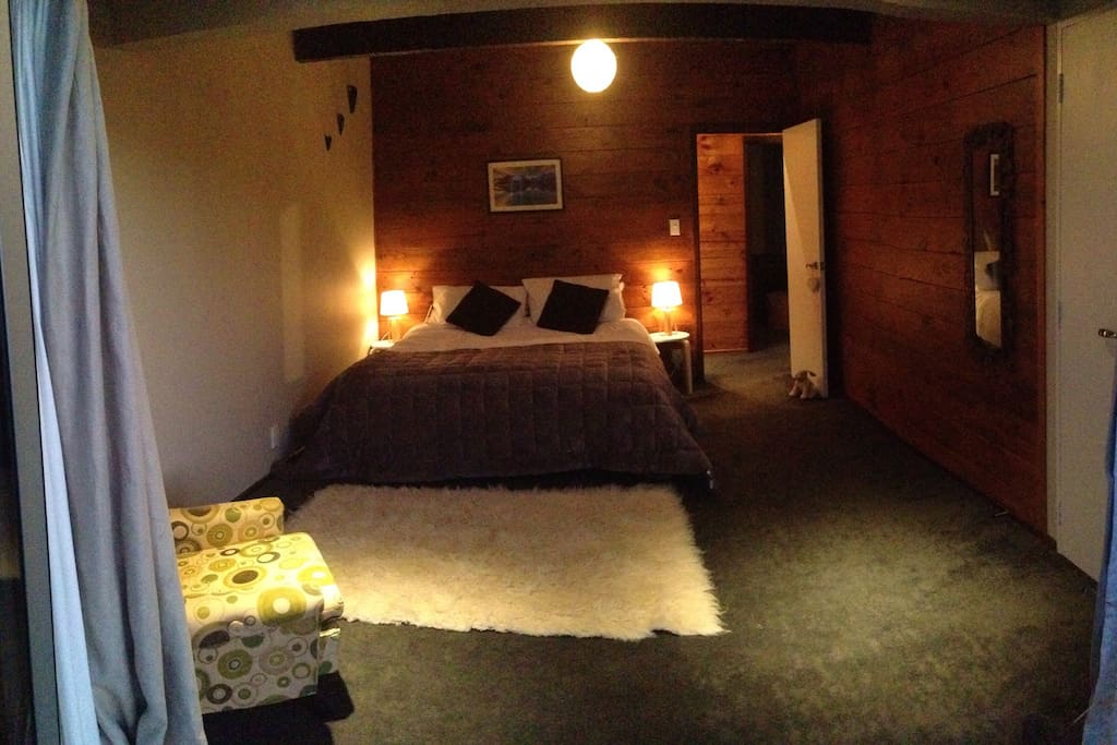 Master bedroom with King size bed and doors opening straight out onto a sunny deck