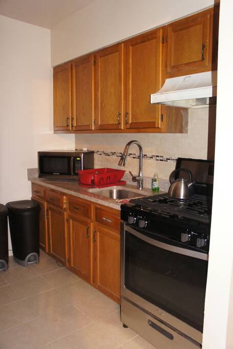 Kitchen with microwave, pots and pan, toaster and coffee maker.