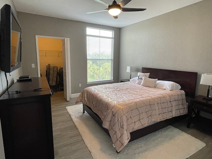 Master bedroom - Hollywood Studios Room - accenting Hollywood glam. Ina kitanda cha ukubwa wa malkia, kabati kamili la nguo, runinga kubwa, tembea kwenye kabati, feni ya dari, taa ya kando ya kitanda na plagi za ziada za kuchaji vifaa kwenye taa.