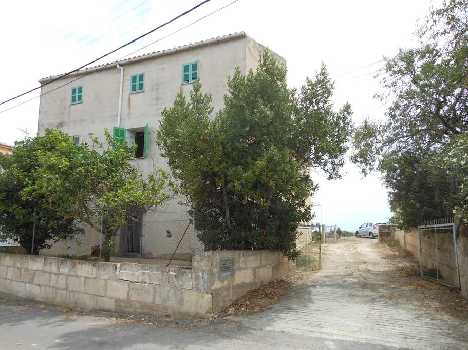 façade de la maison avec une terrasse et chemin privé d'accès dans la cour