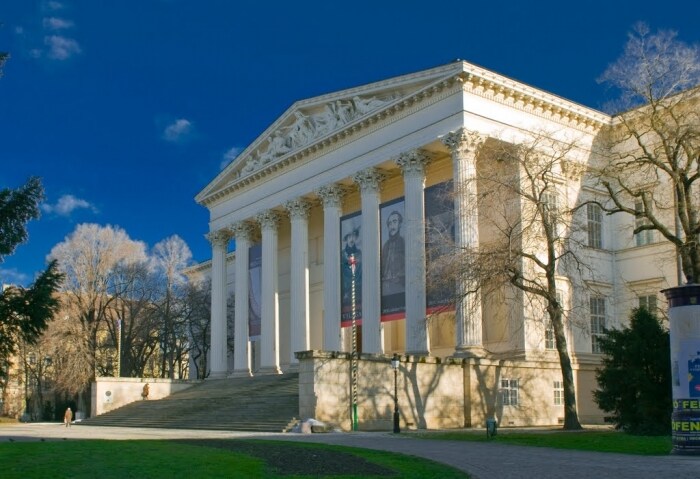 The National Museum stands prominently with its grand columns and steps leading to the entrance. Large banners display historical figures, while the surrounding park features bare trees and manicured lawns, creating a serene environment.