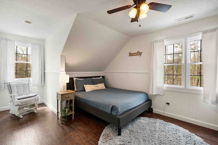 Upstairs bedroom 1 with queen bed, tv, storage, and reading nook
