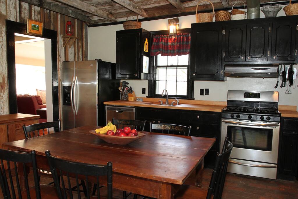Charming kitchen with modern appliances and a wood burning fireplace.