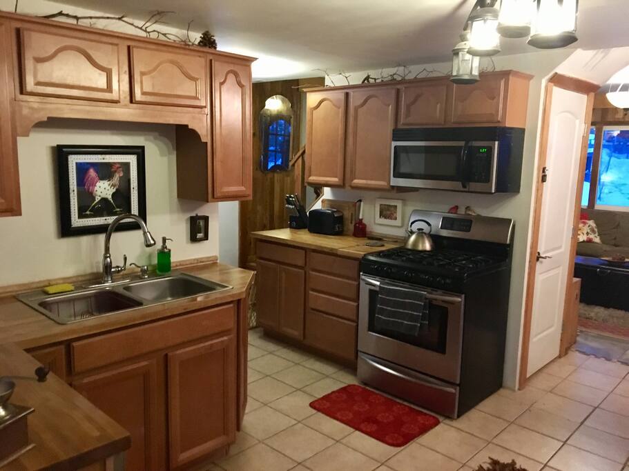 Chef's kitchen with stainless steel appliances (incl dishwasher) spices, dishes, pans, cutlery