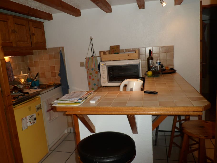 coin cuisine avec frigo, plaques de cuisson, petit four, bouilloire, vaisselle...