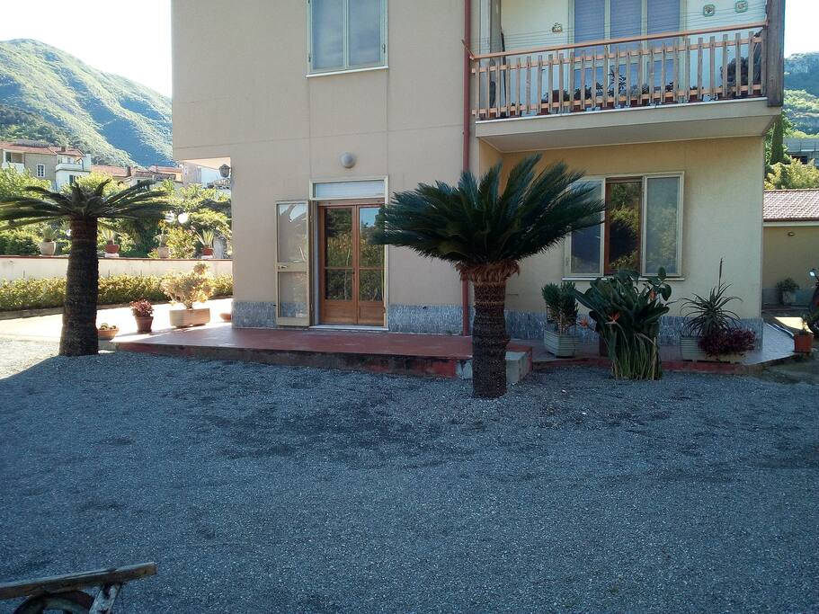 Porta finestra della cucina con dehors e giardino antistante.