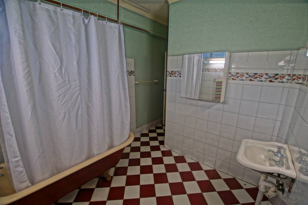The Bathronn with a beautiful old bathtub, shower inside