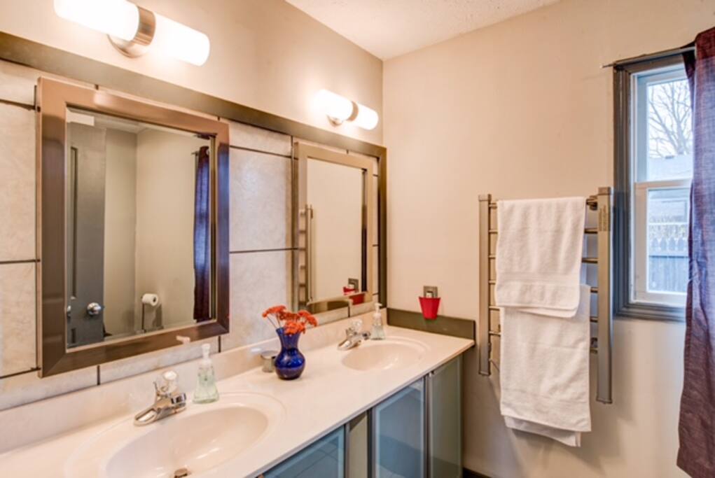A full bath includes double vanities, ceramic tile floors, shower/tub combination, and heated towel rack.