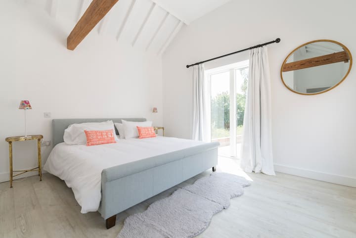 Light airy bedroom with French doors to decking terrace