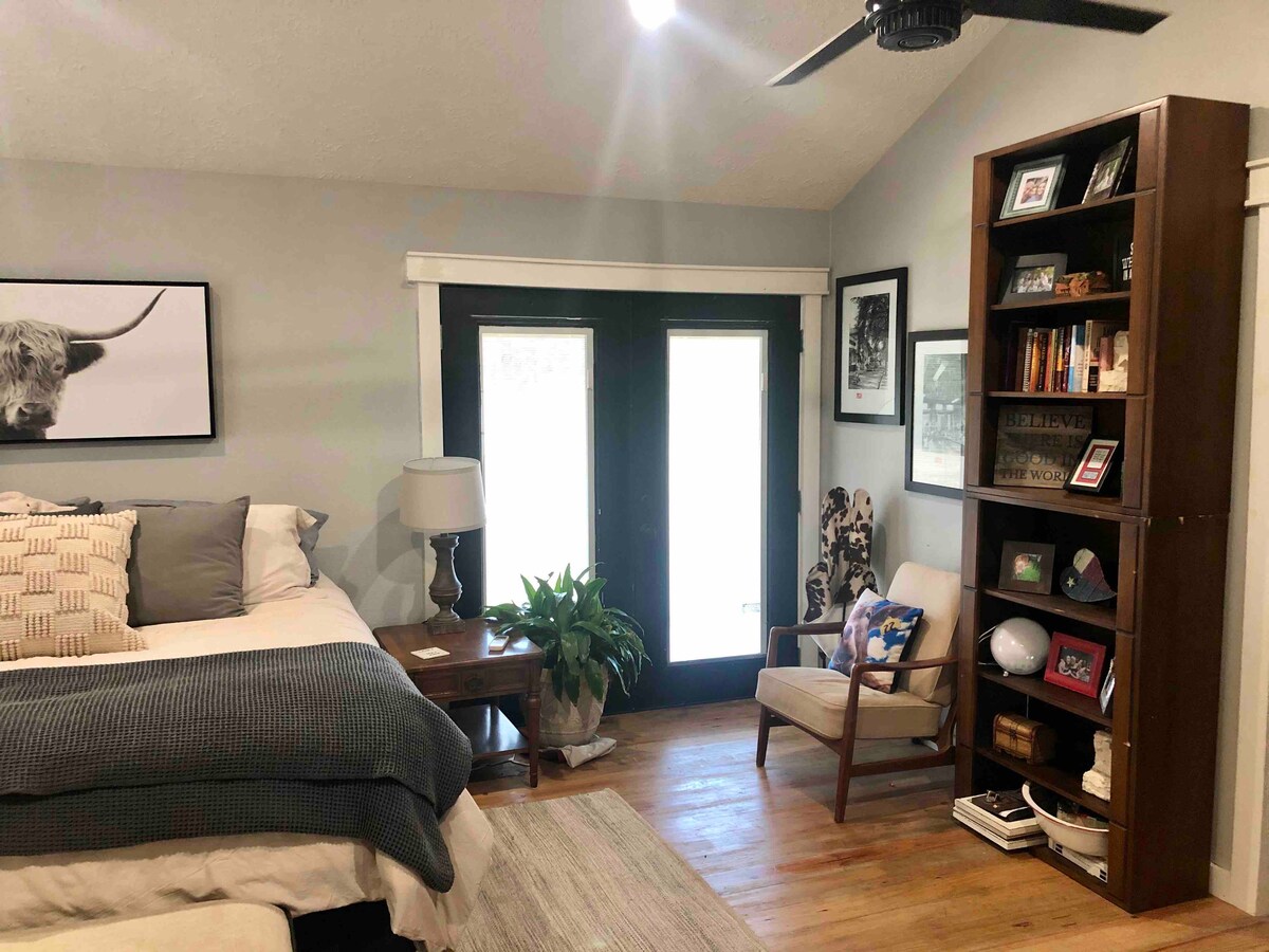 חדר שינה המצויד במיטת קינג סייז, פינת קריאה ודלתות צרפתיות למרפסת האחורית 