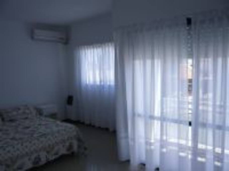 Dos dormitorios con aire acondicionado, dos ventanas y balcón.