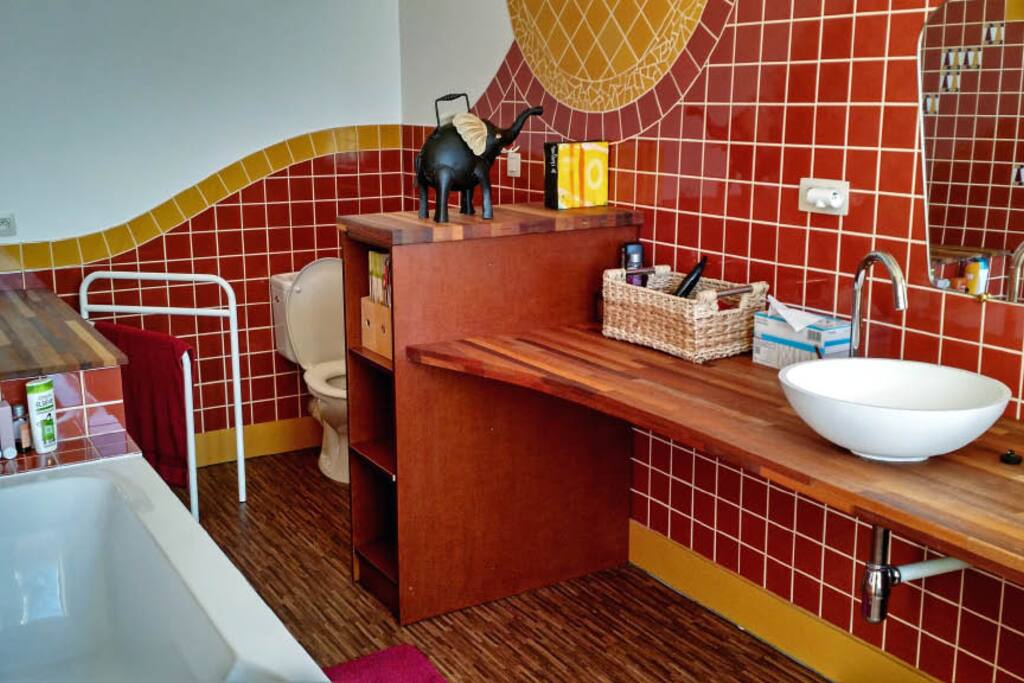 Comfortabele badkamer met ligbad, douche, twee lavabo's en toilet