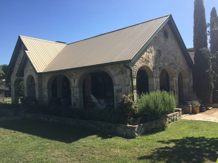 Historical stone farmhouse with a wraparound porch.