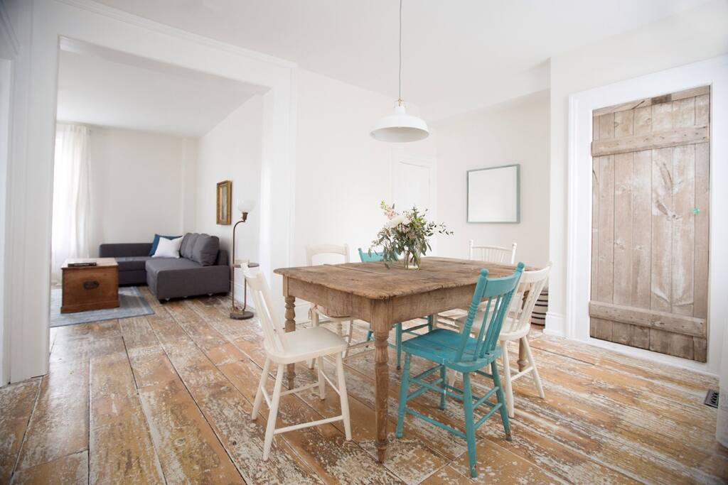The open concept dining room leads into the spacious living room with a pull-out couch (queen bed) and views of the grand homes of the neighbourhood.