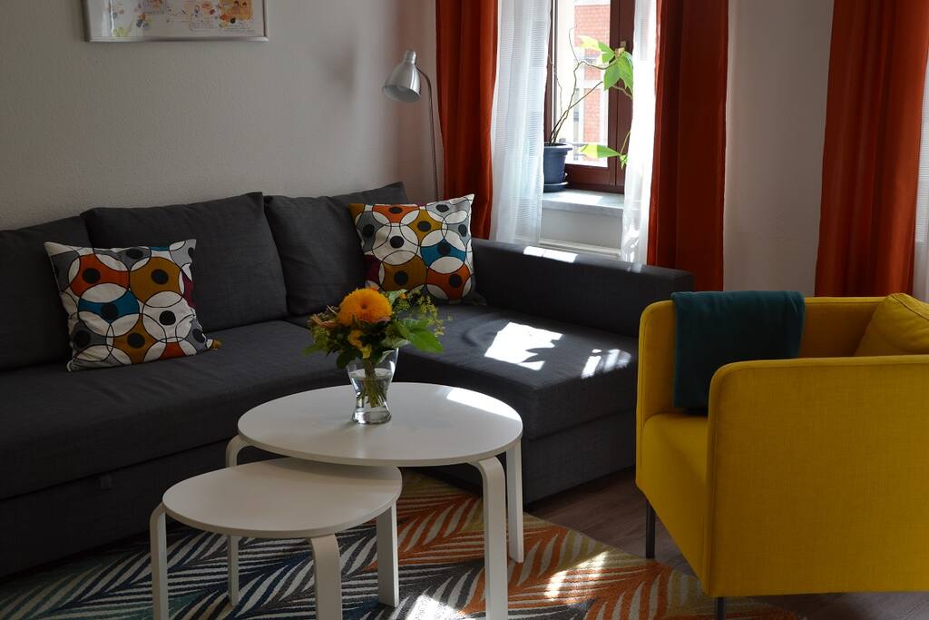 Kuschliges Wohnzimmer mit einem gemütlichen Lesesessel und Flachbild-Smart-TV
