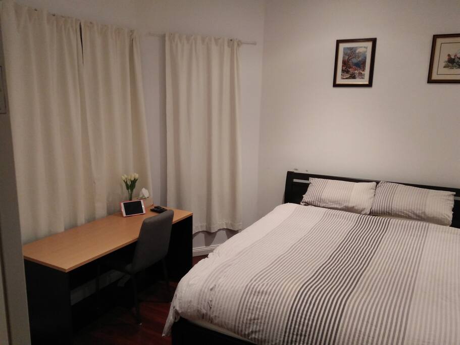 Bed and desk. Curtains block out most light.