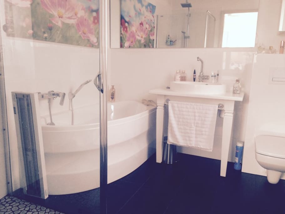 Bad mit kleiner Wanne und Dusche mit Natursteinboden