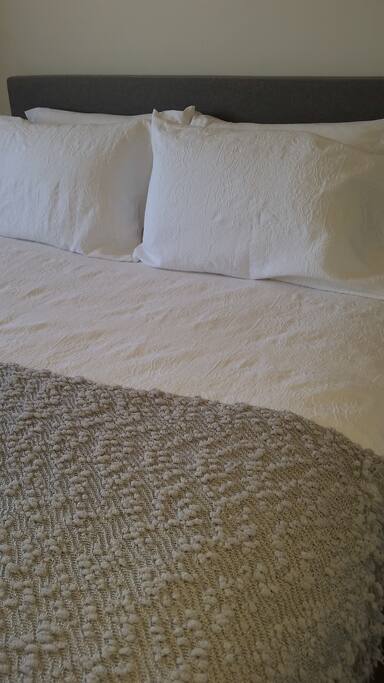 Comfortable queen sized bed with beautiful bedding