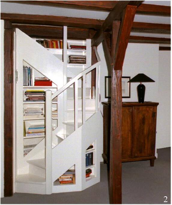 Diese in einer Bücherwand eingebaute Treppe führt zur offenen Schlafgalerie oberhalb des Wohnraumes. Ein zusätzliches Ankleidezimmer ergänzt den offenen Raum.