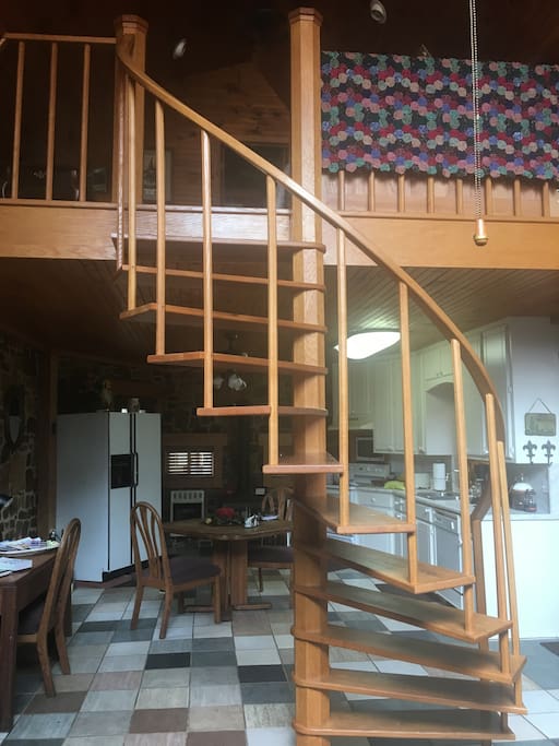 The hand crafted oak spiral staircase separates the living area from the dining/kitchen area while maintaining an open concept.