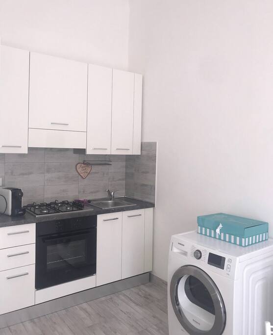 Zona cottura con forno, fornelli, frigo e lavandino + asciugatrice
(lavatrice 10 kg a parte nel ripostiglio)