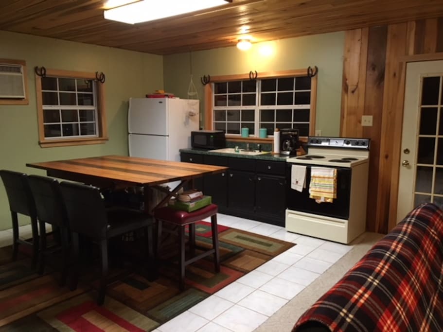 Kitchen area of the cabin. Beautiful handmade wood island counter with counter height bar stools.