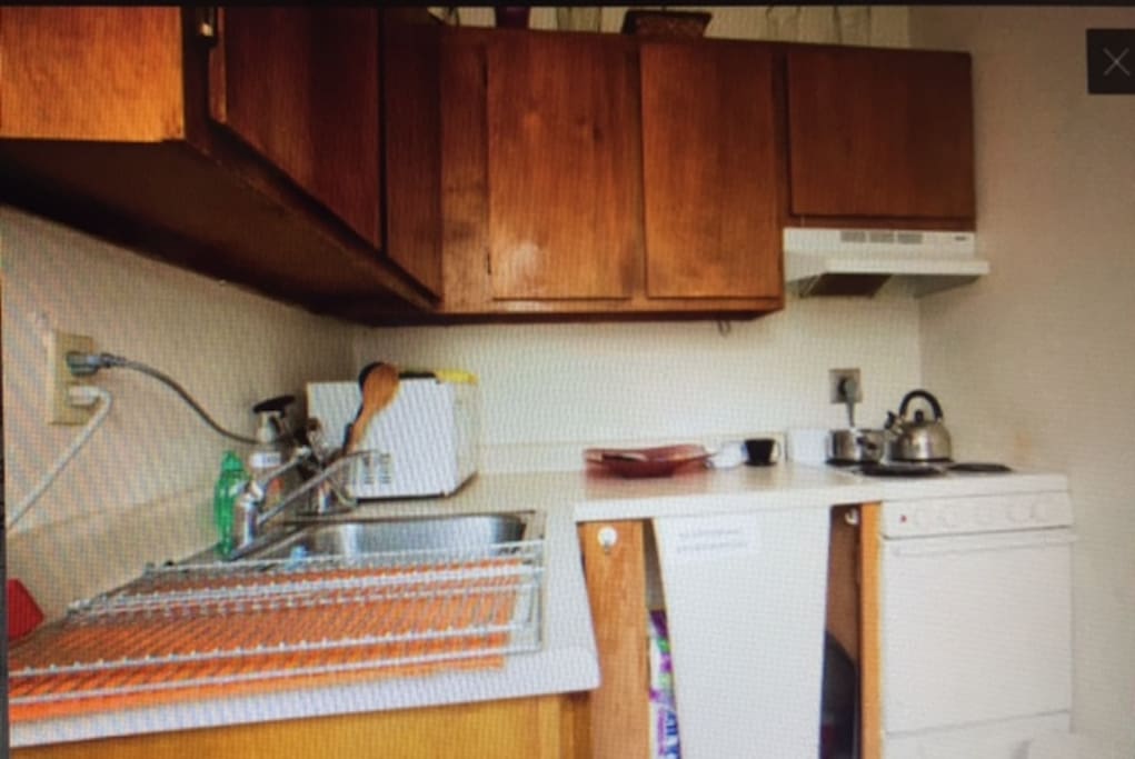 Kitchenette with oven, dishes, microwave, fridge, dishes