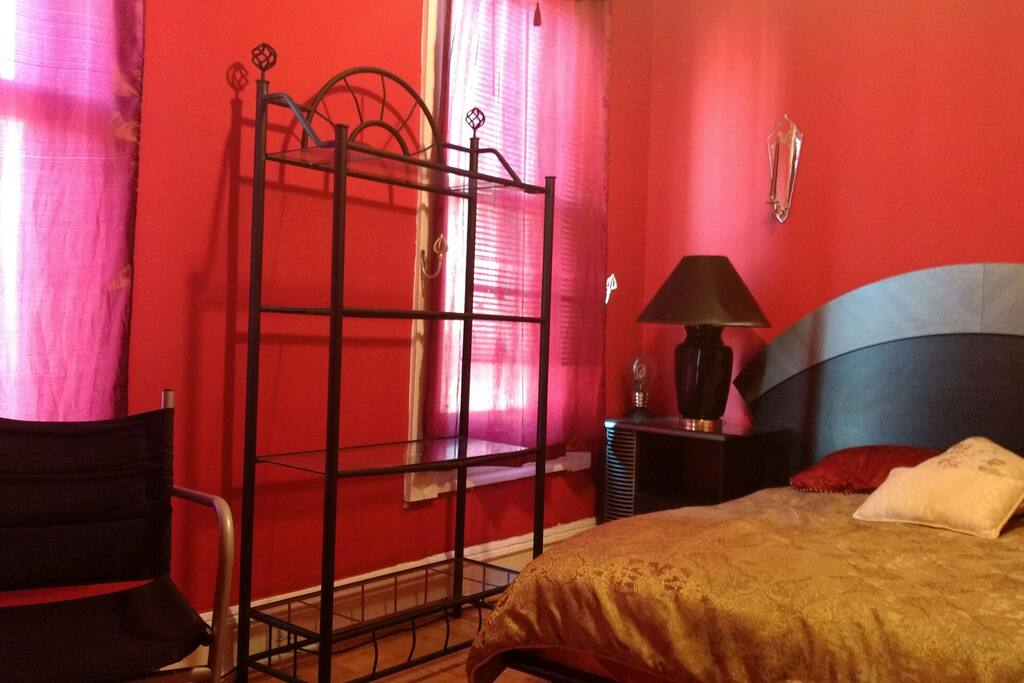 Pictured in room two sunny windows with view street view, chair, shelving which provides space to spread out your personal toileteries. Full platform bed, lamps and tables. Room has ceiling fan and air conditioner is stored in closet to avoid winter drafts.