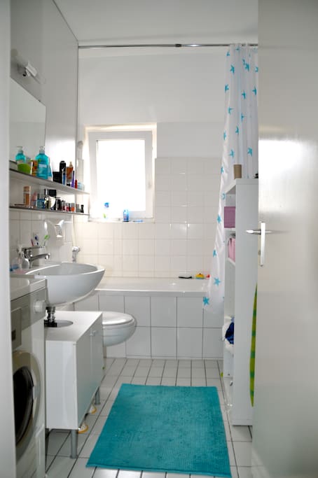 Badezimmer mit Waschmaschine und Badewanne
