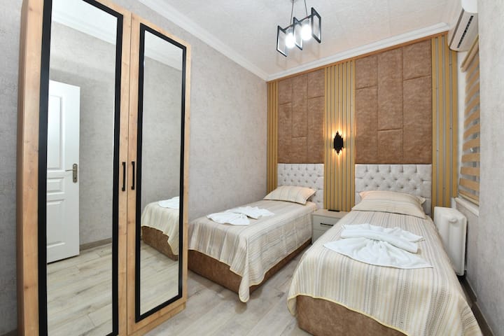 Chumba cha kulala cha kisasa kilicho na vitanda viwili huko Sisli, Istanbul. Inatoa mazingira ya amani ya kulala yenye mapambo mazuri na vitanda vya starehe. Inatoa nafasi ya kuhifadhi na wodi za kutosha. Inatoa likizo ya starehe huko Sisli na muundo wake angavu na wenye nafasi kubwa.