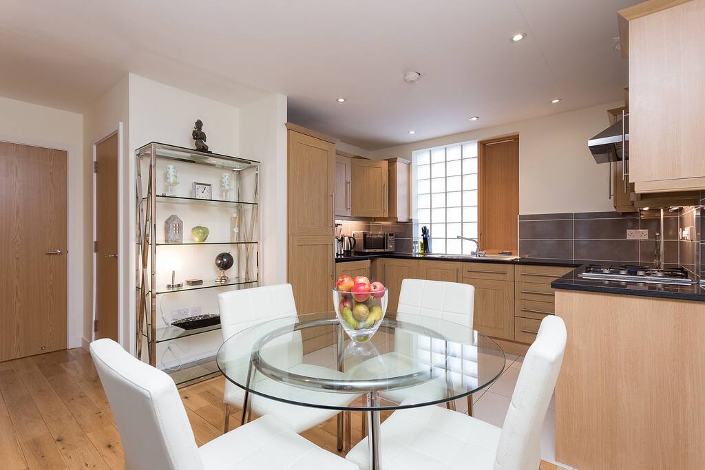 Dining table with four leather chairs, equipped kitchen.