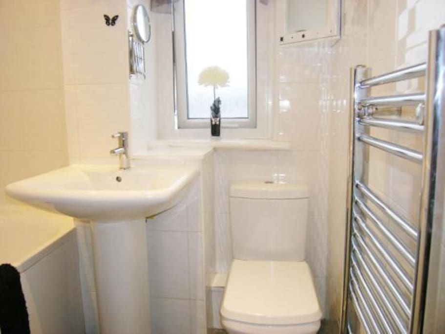 Bathroom with bath, shower and heated towel rail