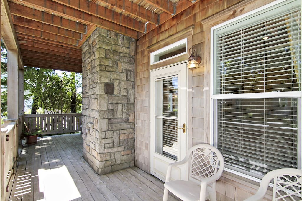 Side porch of Camelot with seating to enjoy the coastal breeze.
