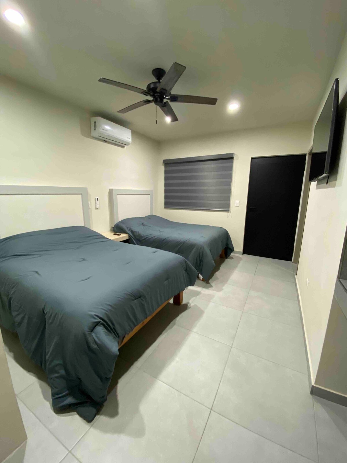 2 spavaće sobe s bračnim krevetom s TV-om, mini splitom, stolom, glačalom, ventilatorom i ormarom.